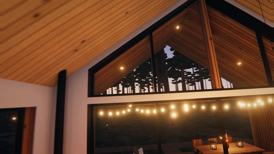 The vaulted kitchen-living room at dusk: the glazed gable with the terrace string lights beyond